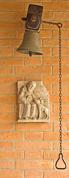 Cloche de l’accueil au Monastère de Bose Cloche et haut-relief en pierre représentant saint François et le loup